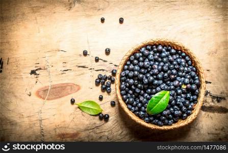 Blueberries in a Cup with leaves. On a wooden table.. Blueberries in a Cup with leaves. On wooden table.