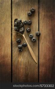 Blueberries in rustic setting with old wooden background with added texture filter