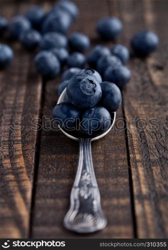 Blueberries on old spoon on grunge wooden board. Natural healthy food. Still life photography