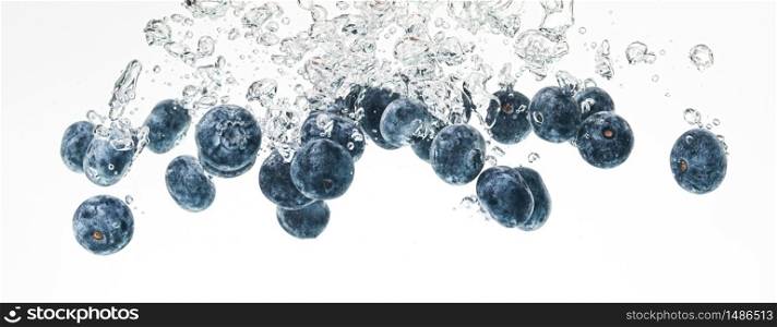 Blueberries sinking into water with air bubbles on white background. Photo for banner. Berries background. Blueberries sinking into water with air bubbles on white background.
