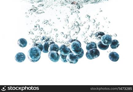 Blueberries sinking underwater with air bubbles isolated on white background. Antioxidant fruit theme.. Blueberries sinking underwater with air bubbles isolated on white background