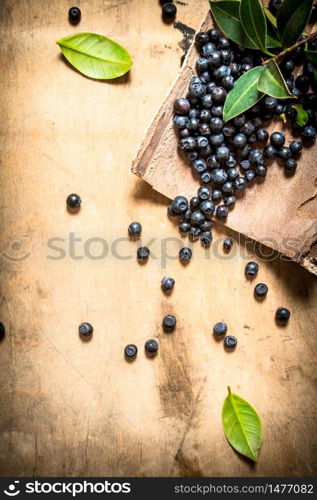 Blueberries with leaves . On a wooden background.. Blueberries with leaves . On wooden background.