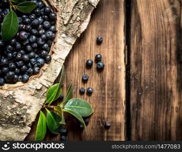 Blueberries with leaves . On a wooden background.. Blueberries with leaves . On wooden background.