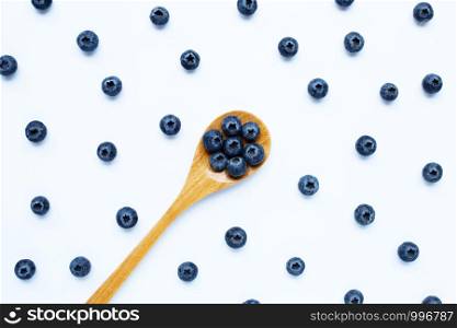 Blueberries with wooden spoon isolated on white background. Top view