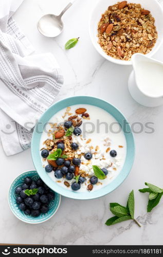 Blueberry and almond granola with greek yogurt, cottage cheese and fresh berries, top view