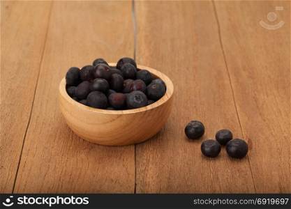 blueberry in wooden bowl on wood background