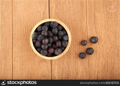 blueberry in wooden bowl on wood background