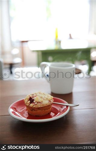 Blueberry muffin with hot tea on wood background