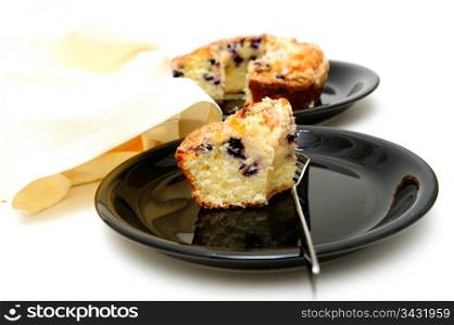 Blueberry Ring Cake. Slice of fresh baked Blueberry Ring Cake served on a black plate with a light colored background