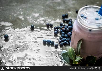 Blueberry smoothie with ice. On a stone background.. Blueberry smoothie with ice. On stone background.