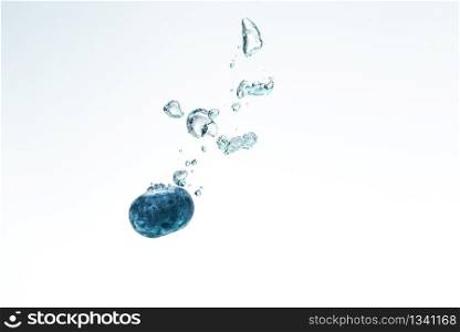 Blueberry splashing into crystal clear water