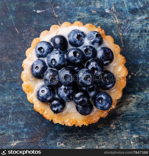 Blueberry tart on blue wooden background