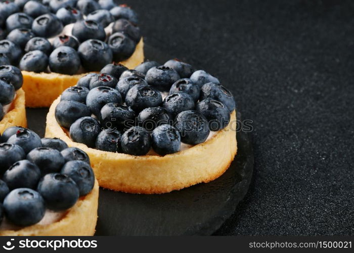 Blueberry tart on the table. Close up of two tartlets with fresh blueberries.. Blueberry tart on the table. Closeup of two tartlets with fresh blueberries