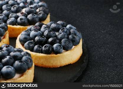 Blueberry tart on the table. Close up of two tartlets with fresh blueberries.. Blueberry tart on the table. Closeup of two tartlets with fresh blueberries