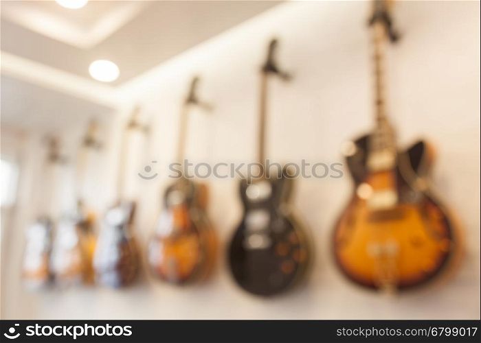 Blur abstract background with guitars hanging on white wall, stock photo