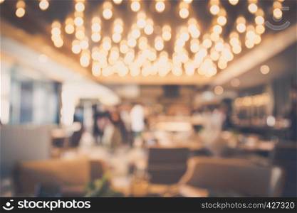 Blur abstract bokeh light background with restaurant or coffee shop or pub modern luxury style with people celebrate and dinning warm tone. For create montage product display.