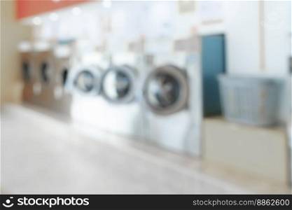Blur background of of qualified coin-operated washing machines in a public store. Concept of a self service commercial laundry and drying machine in a public room.. Blur background of qualified coin-operated washing machines in a public store.