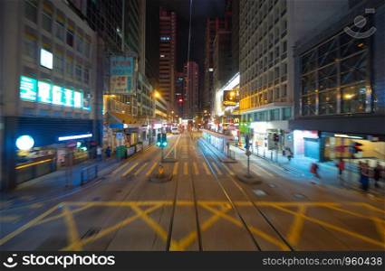Blur background of tram or bus view at night. Crowd of people on street of Central district. Transportation for tourists visiting the urban city in travel trip or holiday. Hong Kong Downtown, China