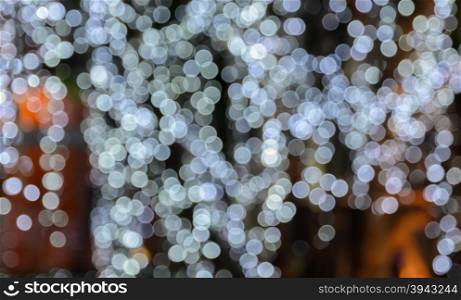 Blur bokeh background of Christmas lights hanging on tree