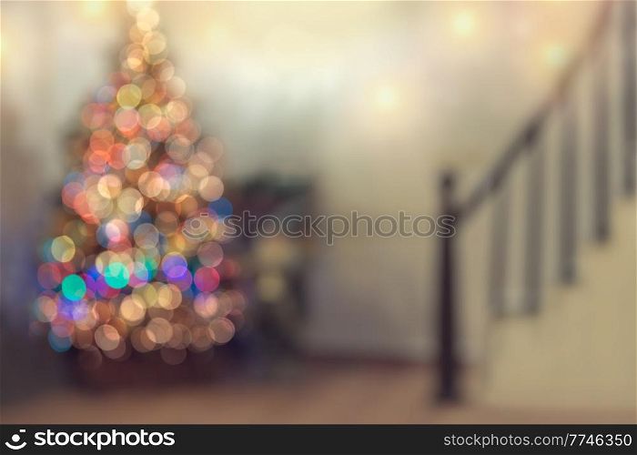 Blur Christmastime Background. Cozy Xmas Decorated Home. Bokeh Glowing Garland on Christmas Tree. Merry Christmas and Happy New Year.. Defocused Christmas Decor