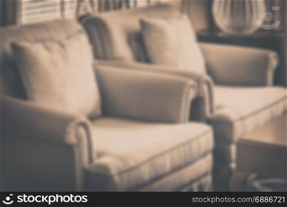 blur image of decorative pillows on a casual sofa in luxury living room with vintage style effect