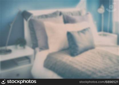 blur image of decorative pillows on bed with blue wall bedroom