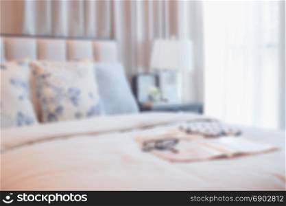 blur image of elegant bedroom interior design with floral pattern pillows on bed