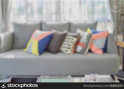 blur image of modern living room design with colorful pillows on sofa for background