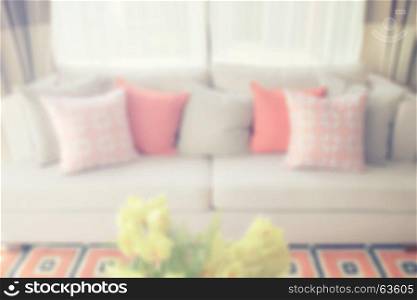 blur image of orange scheme pillows and graphic ogange carpet in living room