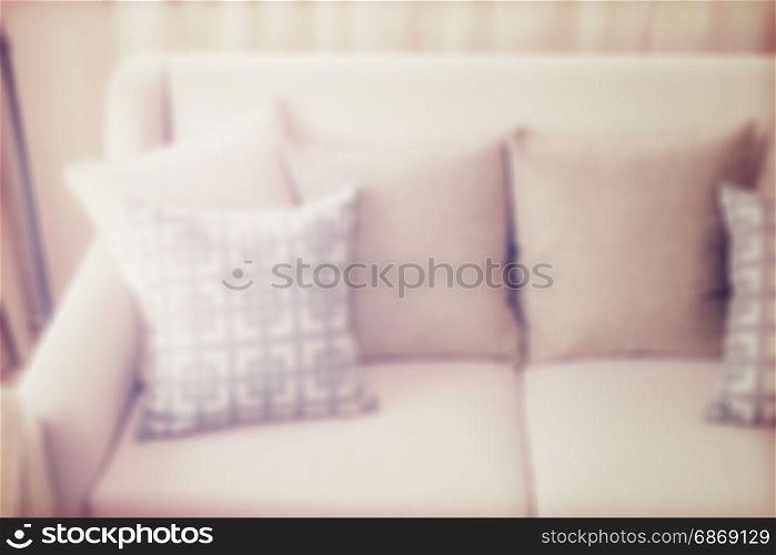 blur image of pattern pillows on beige sofa in the living room