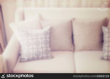 blur image of pattern pillows on beige sofa in the living room