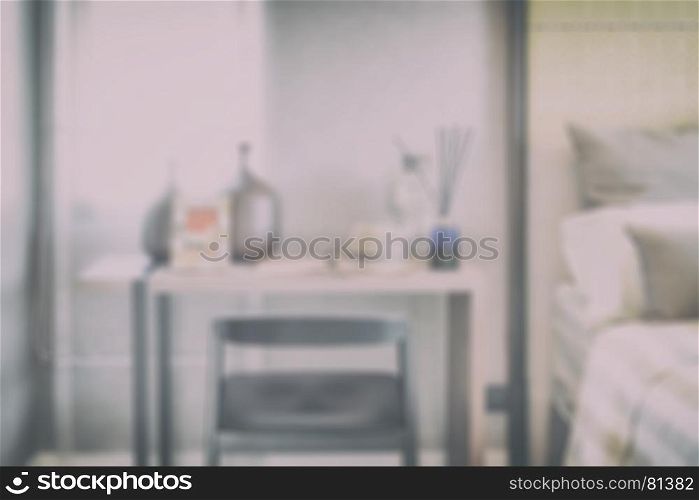 blur image of wooden table with black chair in modern working area at home