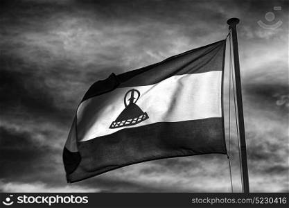 blur in lesotho waving national flag in the cloudy sky
