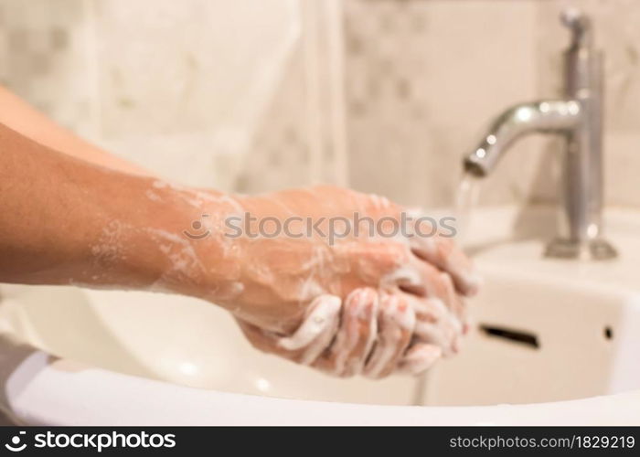 Blur of man washing hands rubbing with soap prevention for coronavirus