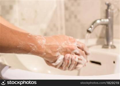 Blur of man washing hands rubbing with soap prevention for coronavirus