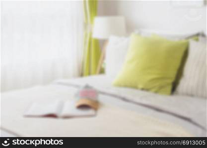 blur of modern bedroom with green pillow on bed for background