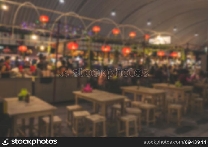 Blur people eating food at the market.