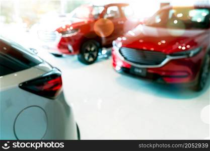 Blur red and white car parked in luxury showroom. Car dealership office. New car parked in modern showroom. Car for sale and rent business concept. Automobile leasing and insurance background.