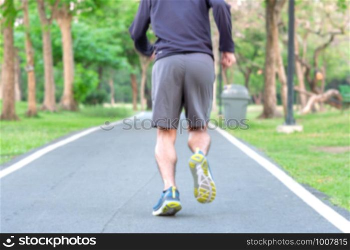 blur Young athlete man with running shoes in the park outdoor, male runner jogging on the road outside, asian Fitness walking and exercise on footpath in morning. wellness and sport concepts