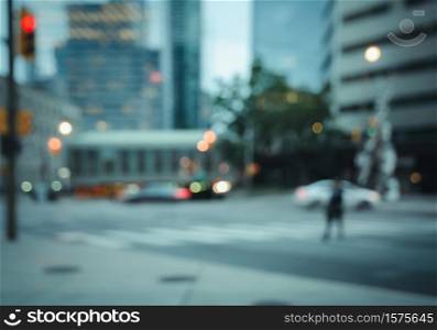 Blurred a man walking on pedestrian crossing the street in the city with cars, traffics light colorful bokeh and buildings background