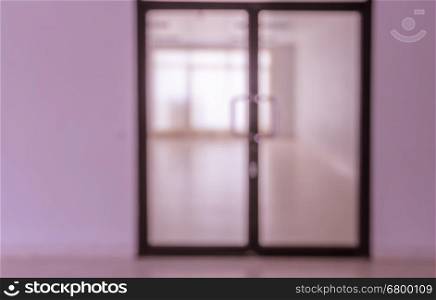 Blurred abstract background interior of empty room with glass door