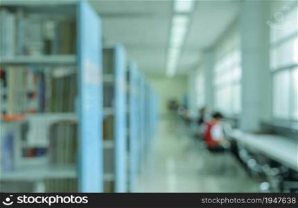 Blurred abstract background of bookshelves and interior of college or university library room with textbooks and reading area
