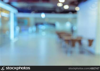 Blurred abstract background of empty cafeteria in University or food court in shopping mall. Blue tone image