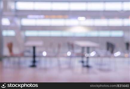 Blurred abstract background of empty cafeteria in University or food court in shopping mall. Pink tone image