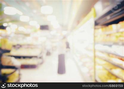 blurred abstract background of people shopping in supermarket with miscellaneous product on shelves