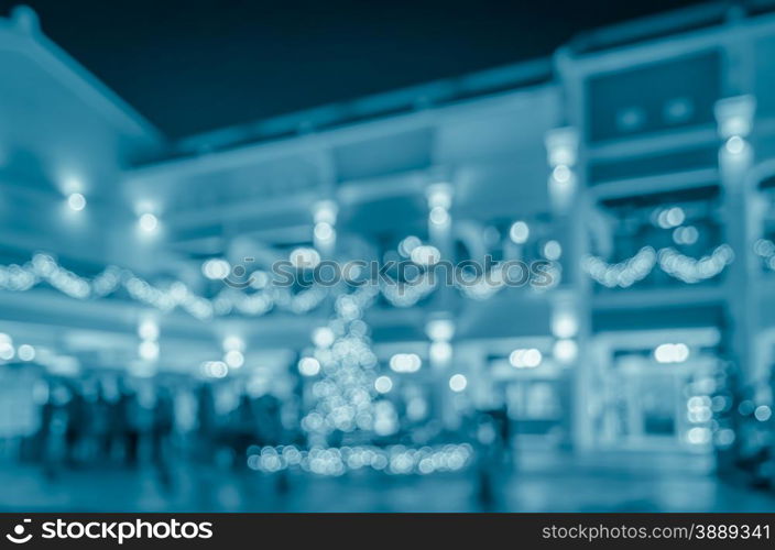 Blurred abstract city night life background with people walking on urban street in blue tone color image