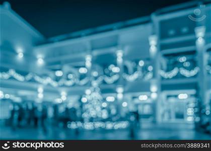 Blurred abstract city night life background with people walking on urban street in blue tone color image