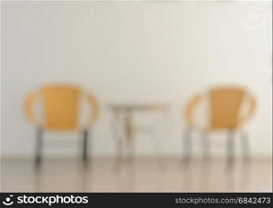 Blurred abstract image of yellow chairs with table in lobby or restaurant for background