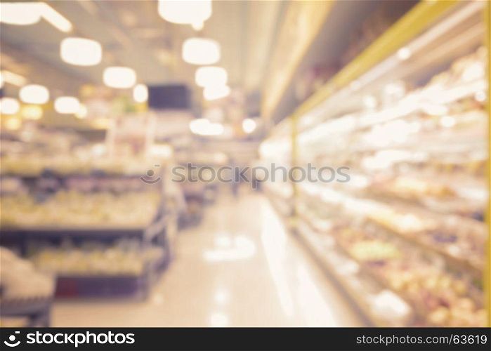 blurred abstract interior of people shopping in supermarket and miscellaneous product on shelves with vintage filter effect