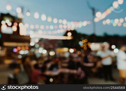 blurred background at night market festival people walking on road.